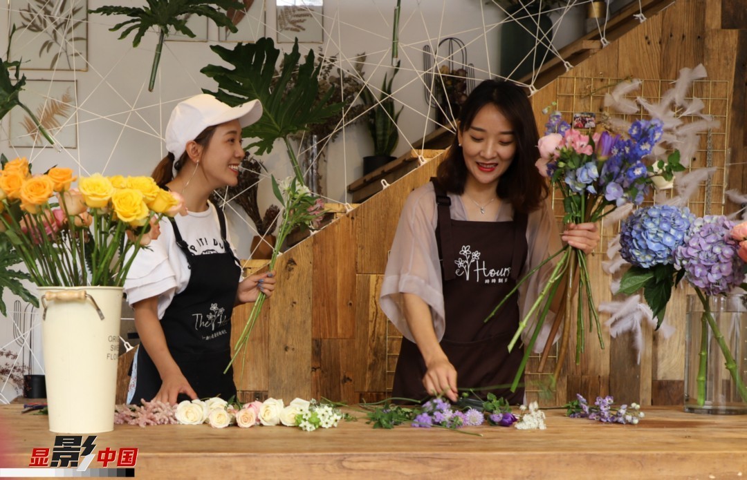 “昆明是鮮花的原產(chǎn)地，有亞洲最大的鮮切花交易市場，可以說具備開花店的天時(shí)地利；另外和很多女孩一樣，我從小也就有開花店的夢想！”說起當(dāng)初的決定，王黎媛說一是因?yàn)閴粝耄硗庖哺ッ鬟@個(gè)城市產(chǎn)花、賣花的“基因”有關(guān)。圖為王黎媛和同事在制作花束。新華網(wǎng) 周亞平/攝 念新洪/文